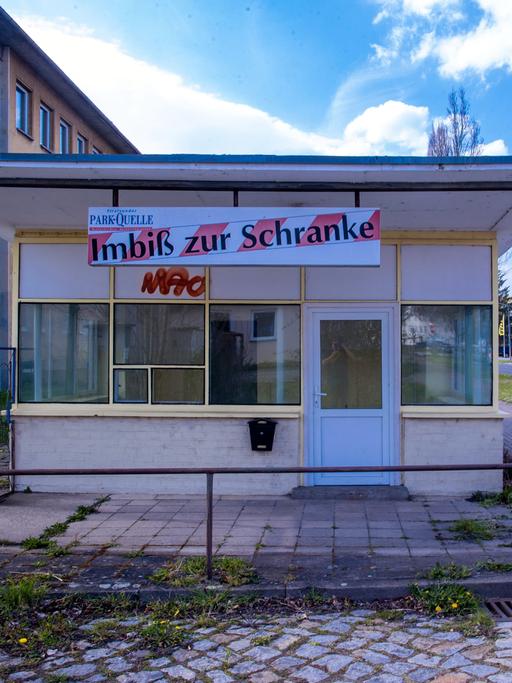 Ein Radfahrer fährt an einem leerstehenden Schnellimbiss vorbei.