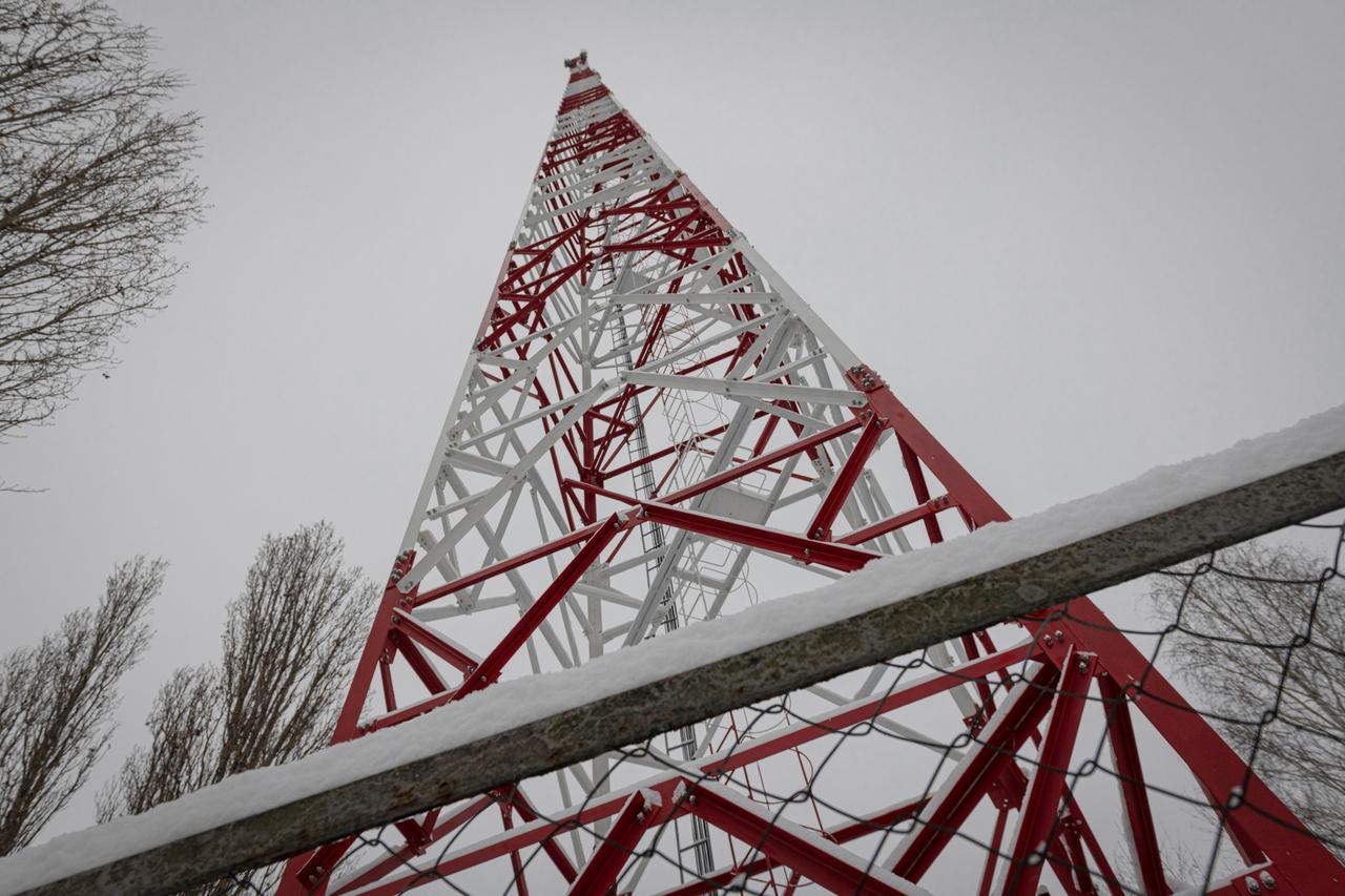 Ein Telefonmast des ukrainischen Mobilfunkunternehmers Kyivstar. Er hat die Farben rot und weiß.