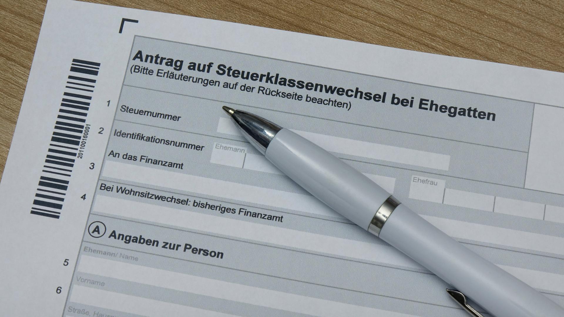 Auf einem ausgedruckten Antragsformular liegt ein Kugelschreiber. Das Formular trägt die Überschrift „Antrag auf Steuerklassenwechsel bei Ehegatten“ 