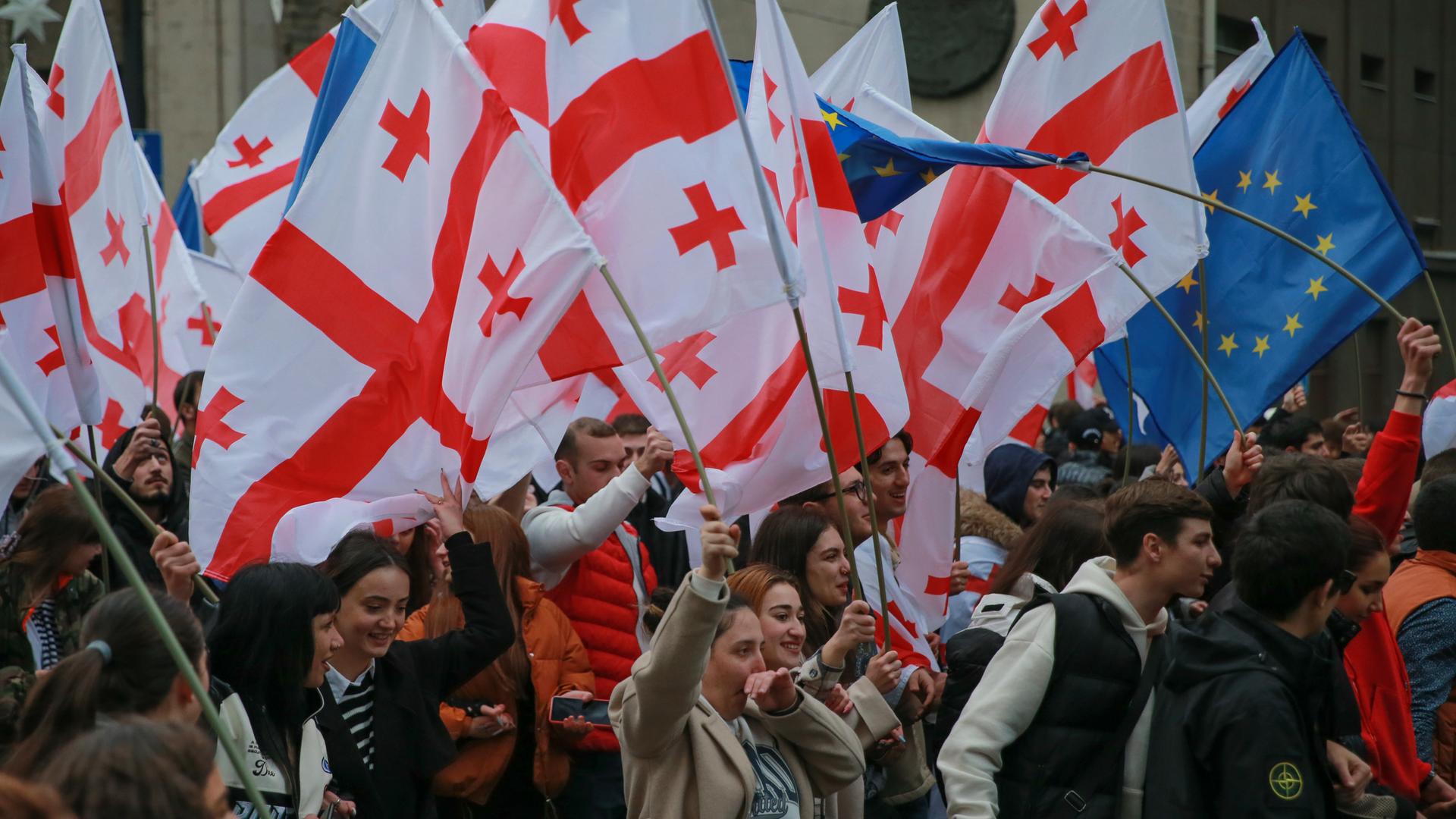 Menschen schwenken in der georgischen Hauptstadt Tiflis Nationalfahnen auf dem Freiheitsplatz, um den Status als EU-Beitrittskandidat zu feiern.