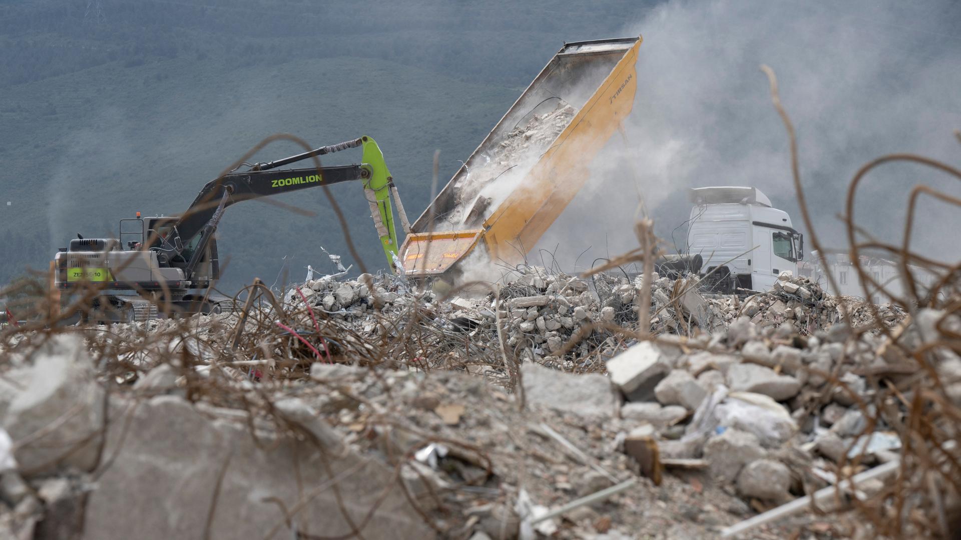 Bagger sind auf einer riesigen Fläche am Stadtrand von Antakya damit beschäftigt den dort abgeladenen Schutt zerstörter Häuser zu planieren (Luftaufnahme mit einer Drohne). Bagger sind auf einer riesigen Fläche am Stadtrand von Antakya damit beschäftigt den dort abgeladenen Schutt zerstörter Häuser zu planieren (Luftaufnahme mit einer Drohne).
