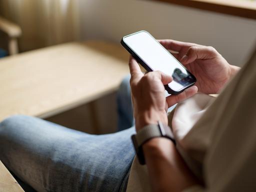 Nahaufnahme von einer Person, die auf ein Smartphone schaut.