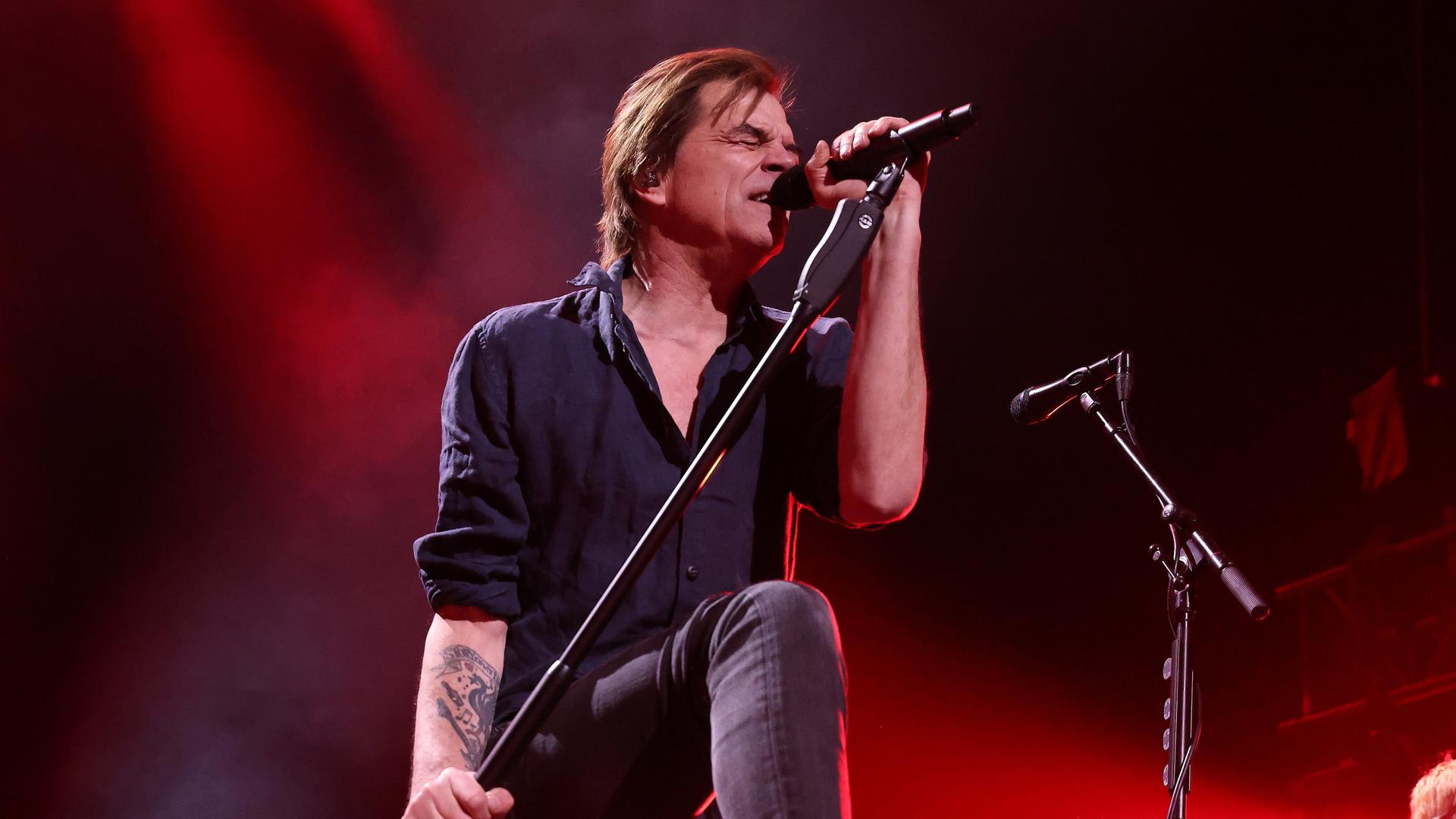 Campino, der Frontmann der Toten Hosen, steht auf einer Bühne und singt mit geschlossenen Augen in ein Mikrofon.