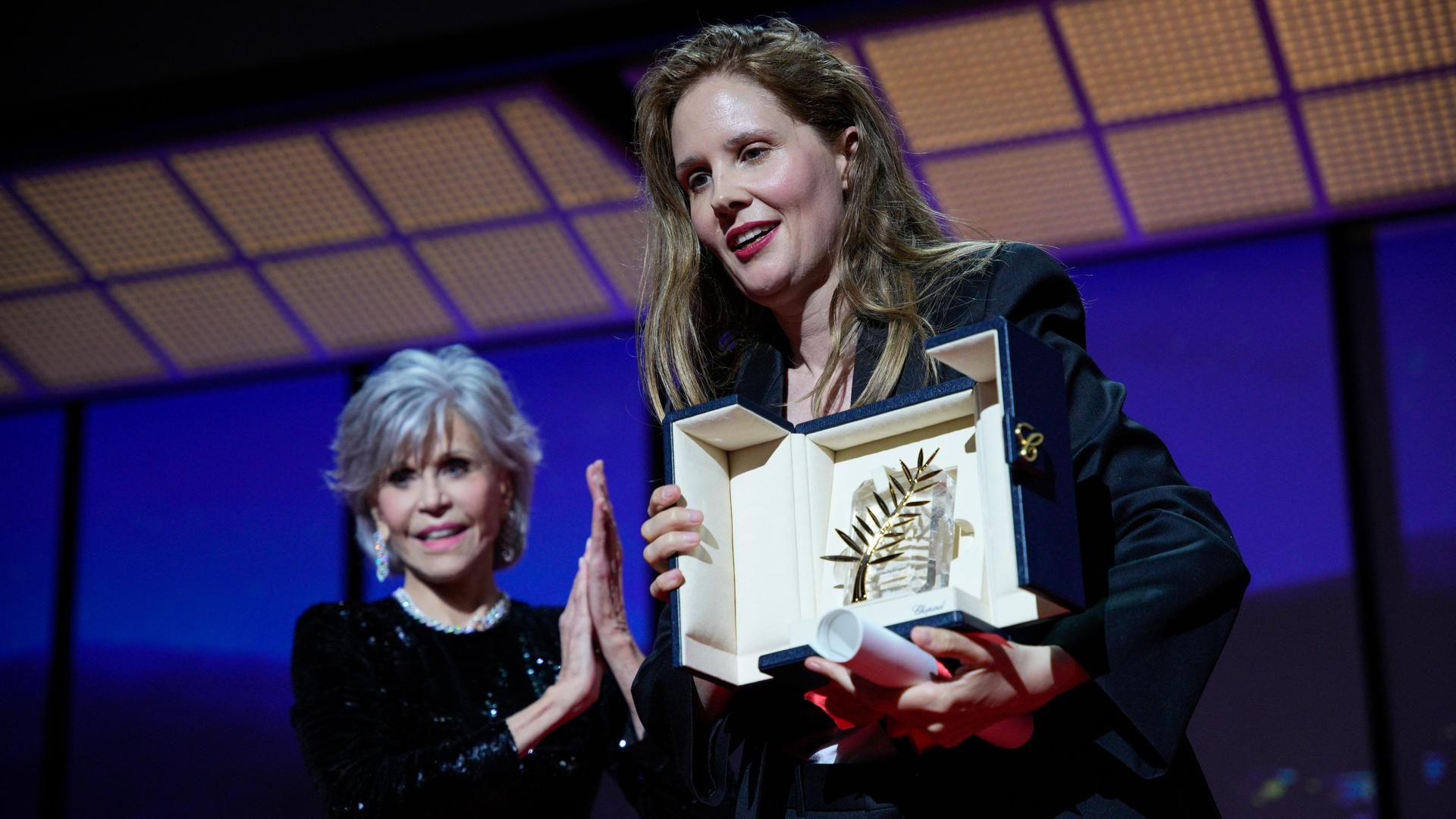 Justine Triet, rechts, nimmt die Goldene Palme für "Anatomie eines Falls" entgegen, die von Jane Fonda, links, während der Preisverleihung der 76. Internationalen Filmfestspiele in Cannes, Südfrankreich, überreicht wurde