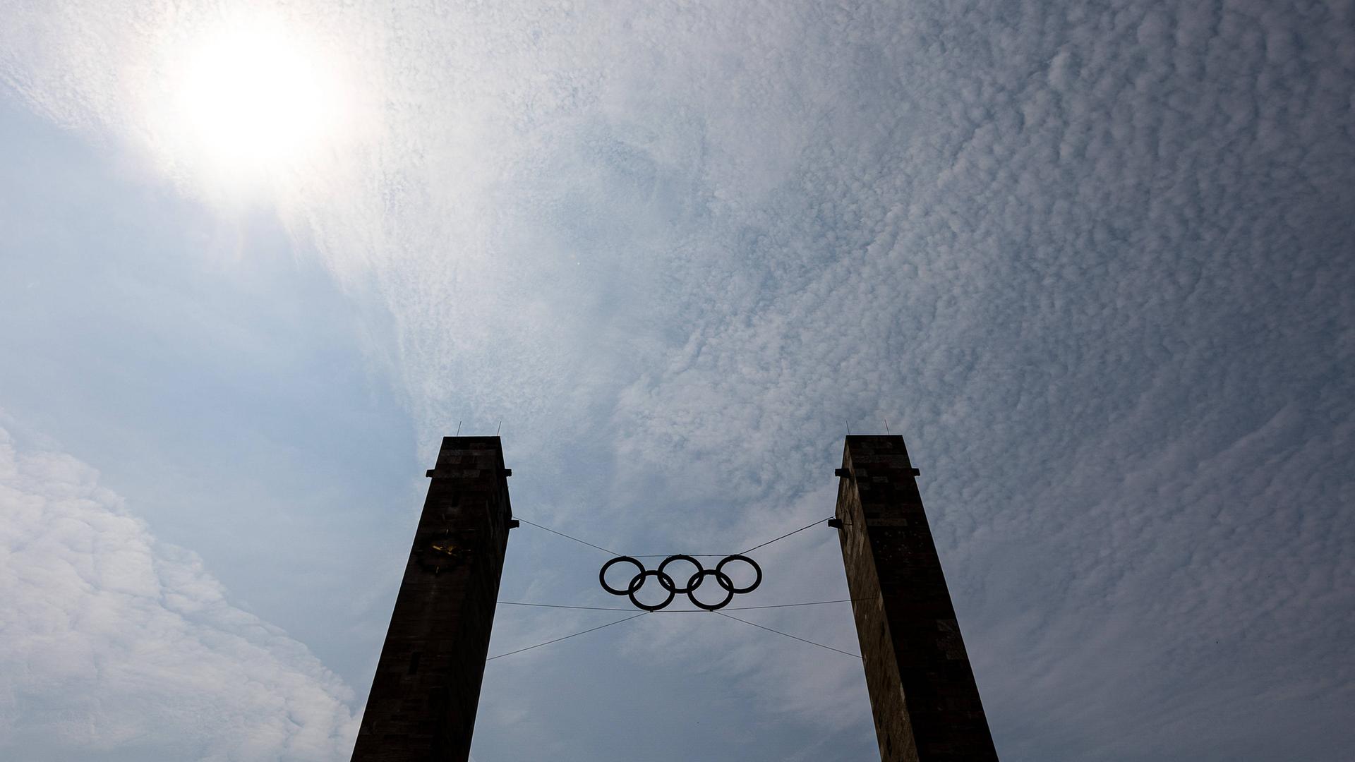Die Olympischen Ringe des Berliner Olympiastadions vor blauem Himmel.
