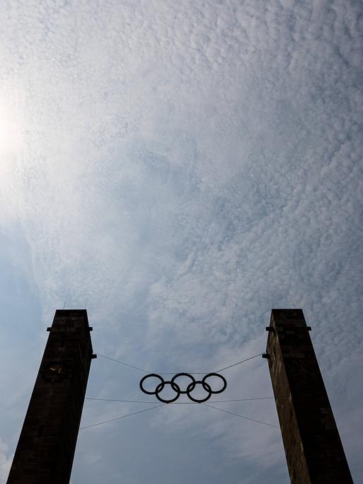 Die Olympischen Ringe des Berliner Olympiastadions vor blauem Himmel.