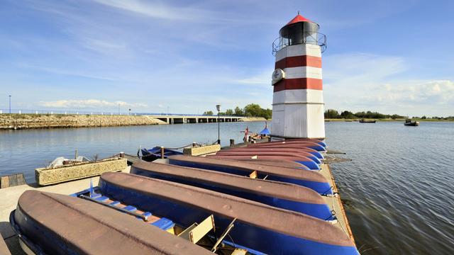 Blick auf den Bootshafen mit Leuchtturm auf der Insel Ummanz. Dahinter ist die Verbindungsbrücke nach Gingst auf der Insel Rügen zu sehen.