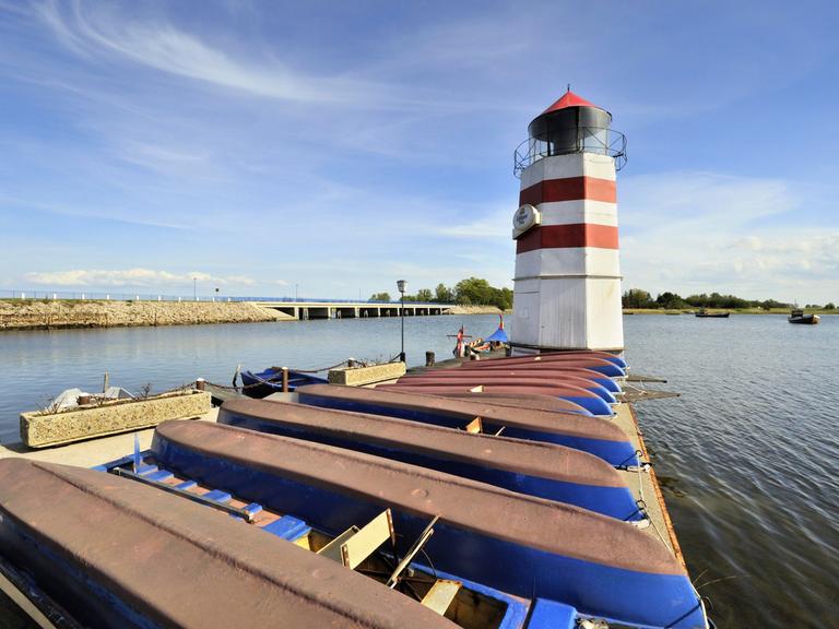 Blick auf den Bootshafen mit Leuchtturm auf der Insel Ummanz. Dahinter ist die Verbindungsbrücke nach Gingst auf der Insel Rügen zu sehen.