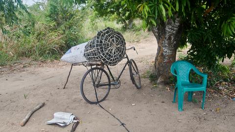 Ein Fahrrad, auf dem ein Sack Holzkohle befestigt ist