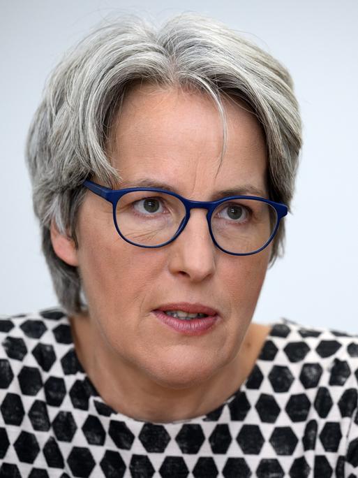 Kerstin Claus, Unabhängige Beauftragte für Fragen des sexuellen Kindesmissbrauchs, guckt mit blauer Brille in die Kamera. Sie hat graues Haar und trägt ein schwarz-weißes Oberteil.