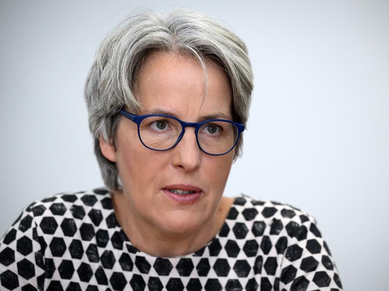 Kerstin Claus, Unabhängige Beauftragte für Fragen des sexuellen Kindesmissbrauchs, guckt mit blauer Brille in die Kamera. Sie hat graues Haar und trägt ein schwarz-weißes Oberteil.