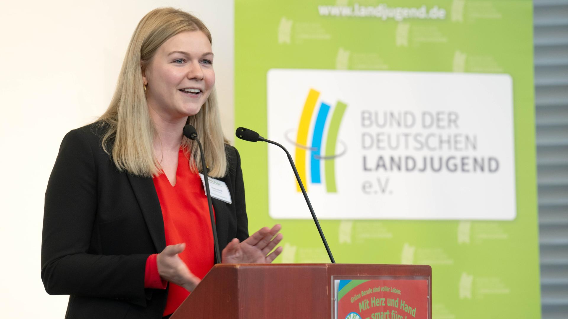 Theresa Schmidt sagte etwas an einem Rednerpult. Dahinter eine Stellwand mit dem Logo der Landjugend. Theresa Schmidt sagte etwas an einem Rednerpult. Dahinter eine Stellwand mit dem Logo der Landjugend.