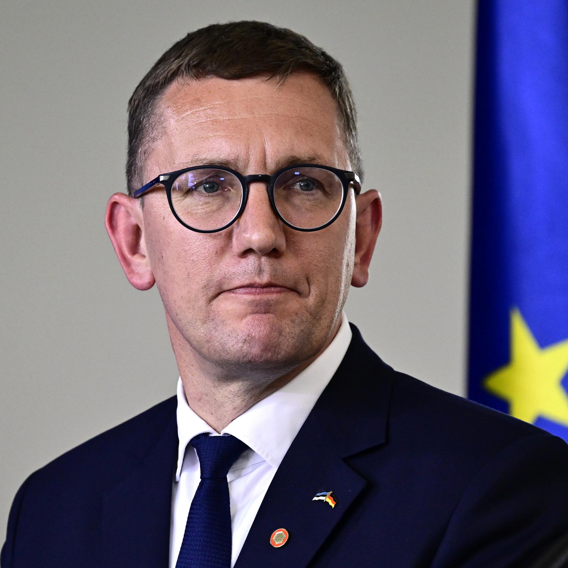 Kristen Michal, Ministerpräsident von Estland, steht vor einer Europa-Fahne. 
