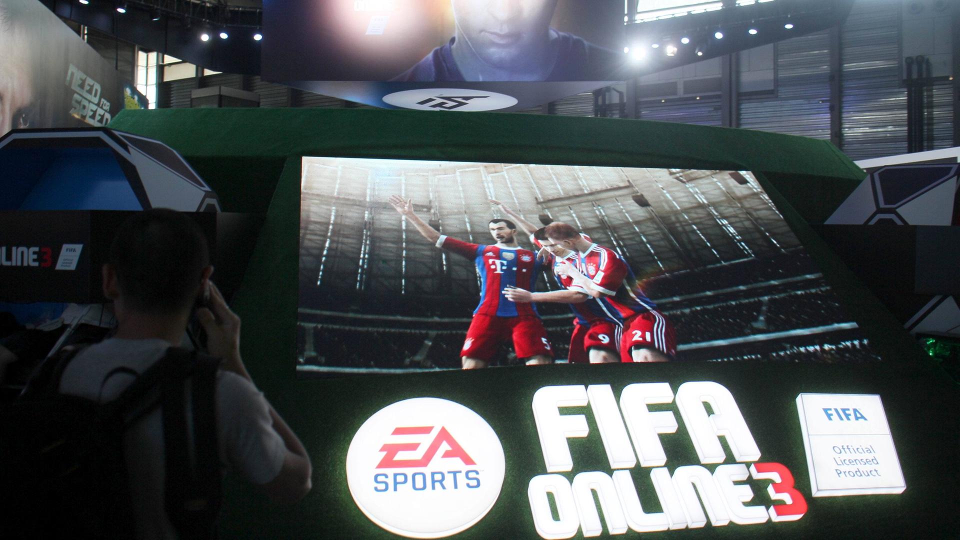 Das Bild zeigt einen Monitor mit virtuellen Spielern des FC Bayern München. Darunter der Name des Herstellers EA. 
