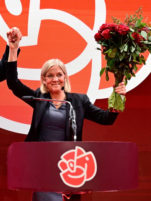 Tobias Baudin, Parteisekretär der Sozialdemokraten, und Parteivorsitzende Magdalena Andersson halten die erhobenen Hände und einen Strauß Rosen in die Höhe Tobias Baudin, Parteisekretär der Sozialdemokraten, und Parteivorsitzende Magdalena Andersson halten die erhobenen Hände und einen Strauß Rosen in die Höhe