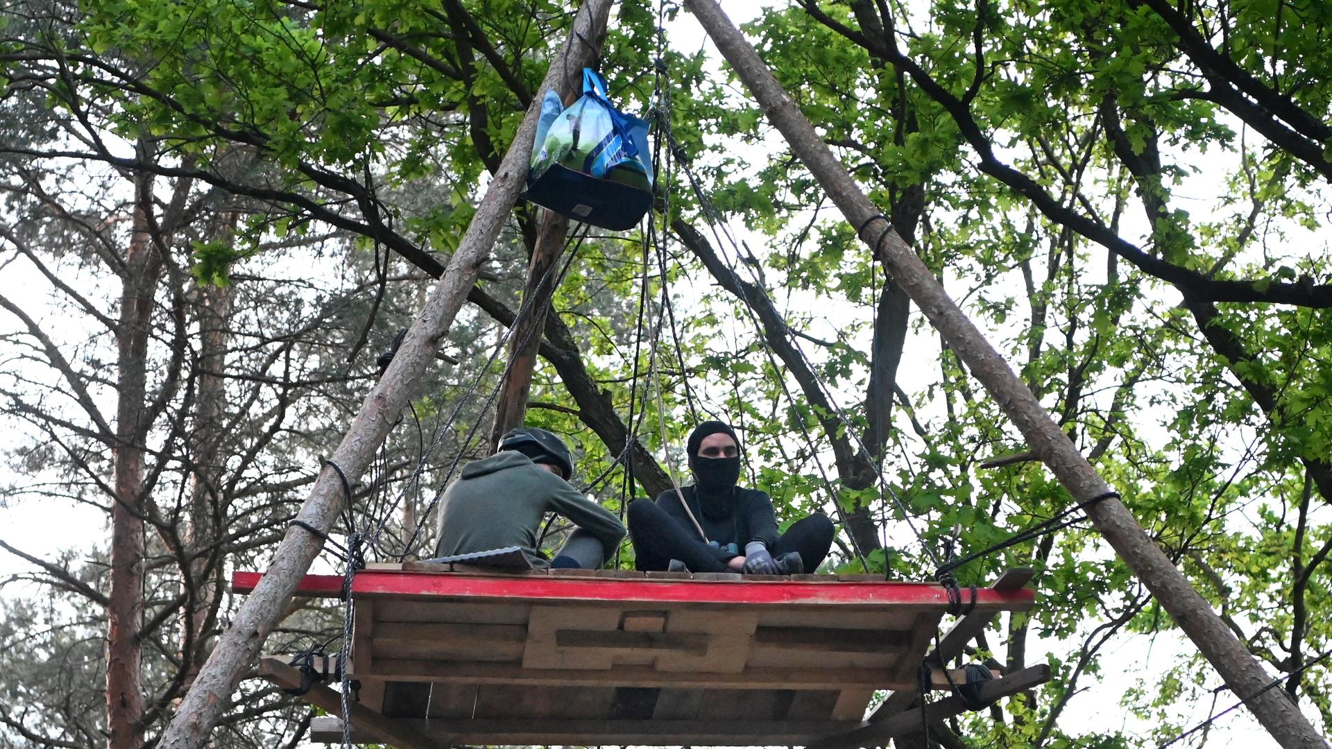 Aktivisten sitzen auf einer Plattform in einem Waldstück in der Wuhlheide. Dort haben sie ein mehr als 20 Fußballfelder großes Waldstück besetzt. Aktivisten sitzen auf einer Plattform in einem Waldstück in der Wuhlheide. Dort haben sie ein mehr als 20 Fußballfelder großes Waldstück besetzt.