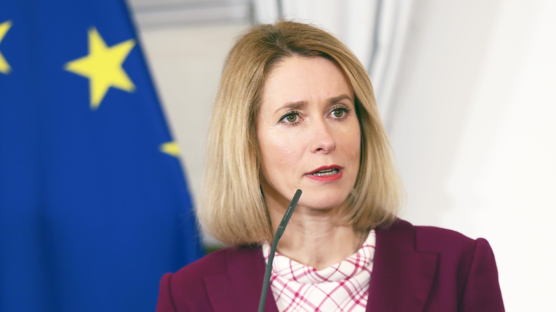 Kaja Kallas spricht an einem Rednerpult, im Hintergrund: die Flagge der EU