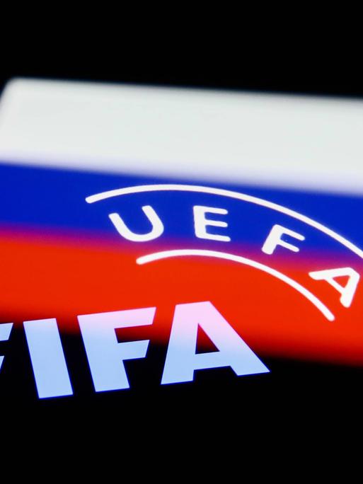 Das Bild zeigt die russische Flagge und auf ihr die Schriftzüge UEFA und FIFA.