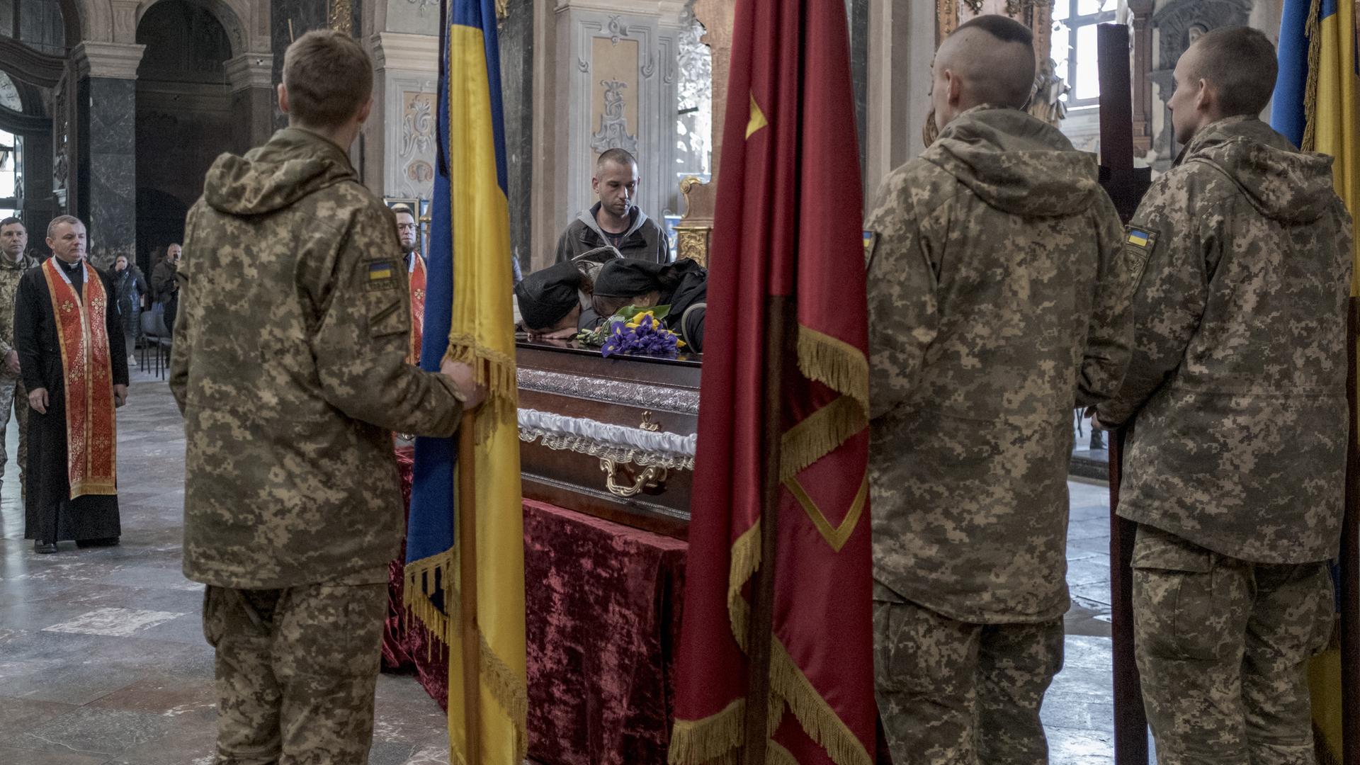 Ukrainische Soldaten bei einer Trauerfeier für einen gefallenen Soldaten in einer Kirche in Lwiw.
