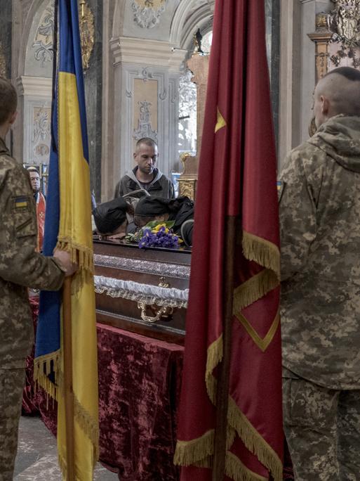 Ukrainische Soldaten bei einer Trauerfeier für einen gefallenen Soldaten in einer Kirche in Lwiw.