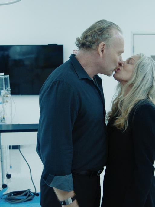 Ein Mann und eine Frau küssen sich in einem Labor.