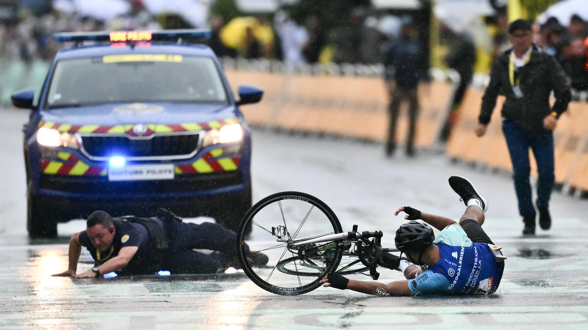 Ein Polizist und ein Mann liegen im Zielbereich bei der Ankunft der Tour de France in Valence auf dem Boden. Ein Polizist und ein Mann liegen im Zielbereich bei der Ankunft der Tour de France in Valence auf dem Boden.