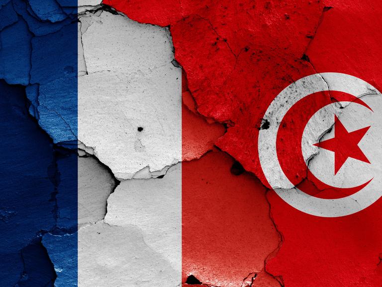 Die Flaggen von Frankreich und Tunesien auf eine rissige Wand gemalt.