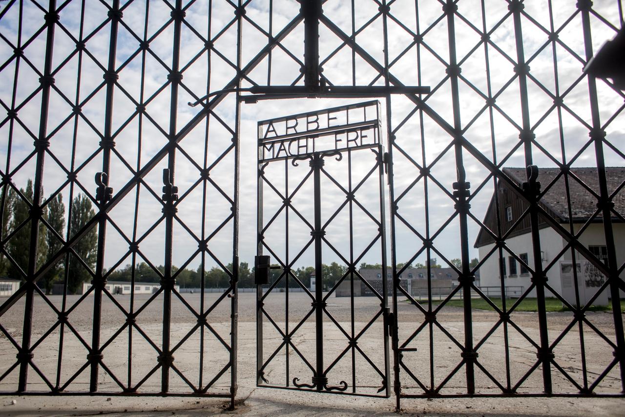 Das Foto zeigt das Eingangstor zum ehemaligen Apellhofplatz in der heutigen KZ-Gedenkstätte Dachau. Die Tür trägt die Nazi-Inschrift „Arbeit macht frei“.