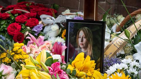 Ein von Blumen umgebendes Foto von Victoria Amelina in einer Kirche bei der Trauerfeier für die verstorbene Schriftstellerin