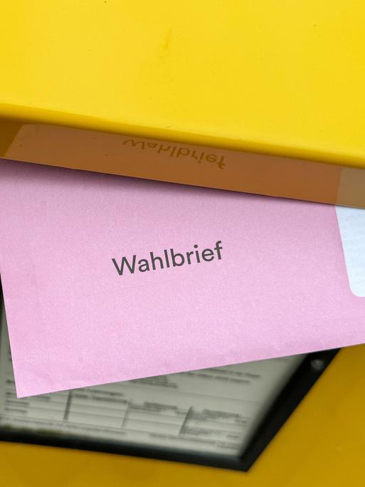 Der rote Wahlbrief für die Briefwahl zur Europawahl 2024 steckt im Briefschlitz eines Briefkastens der Deutsche Post.