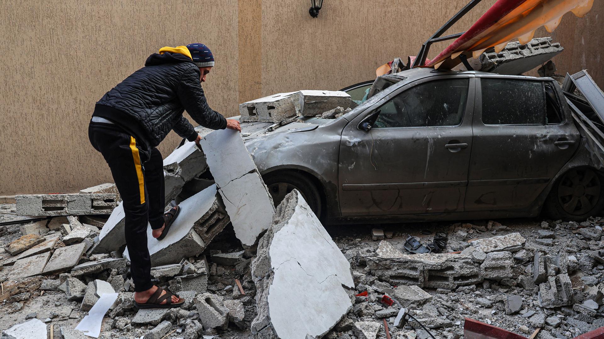 Ein Mann sucht nach einem israelischen Luftangriff in Trümmern nach verwertbaren Gegenständen.