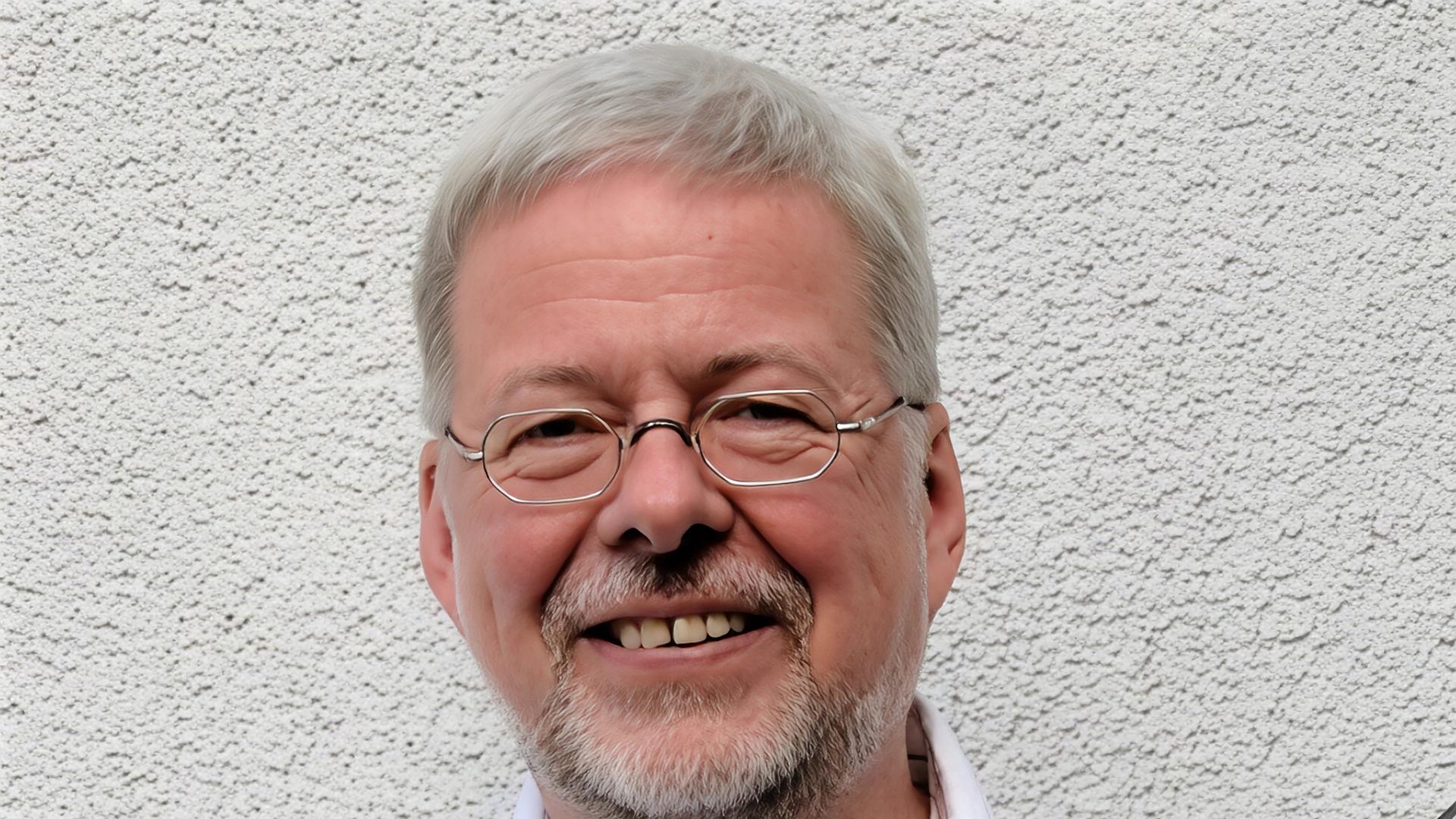 Walter Thomas Heyn lacht in die Kamera, während er seine Gitarre bei sich hat.