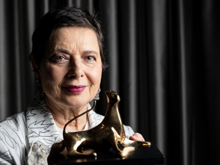 Die Schauspielerin Isabella Rossellini hält ihre Auszeichnung in Locarno in die Höhe. 