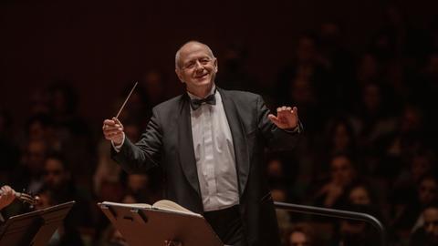 Ivan Fischer dirigiert mit einem großen Lachen auf dem Gesicht.