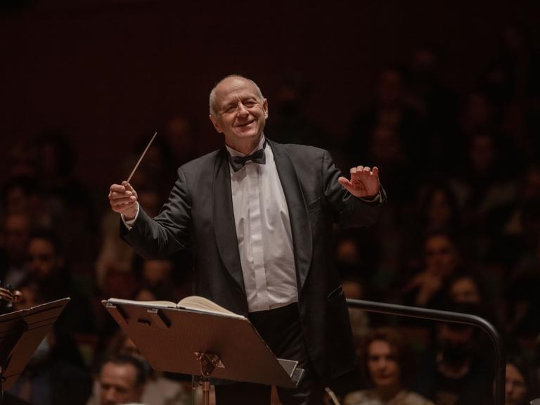 Ivan Fischer dirigiert mit einem großen Lachen auf dem Gesicht.