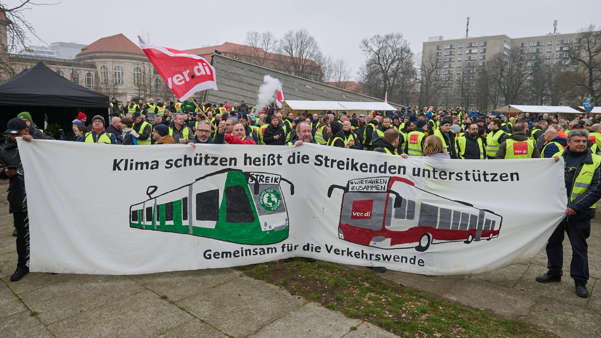 "Klima schützen heißt die Streikenden unterstützen - gemeinsam für die Verkehrswende" steht auf einem Transparent, das Verdi-Demonstranten in Berlin hochhalten.