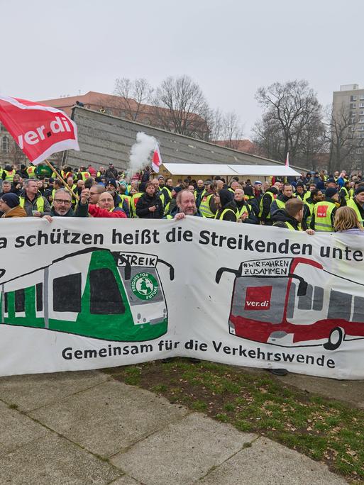 "Klima schützen heißt die Streikenden unterstützen - gemeinsam für die Verkehrswende" steht auf einem Transparent, das Verdi-Demonstranten in Berlin hochhalten.