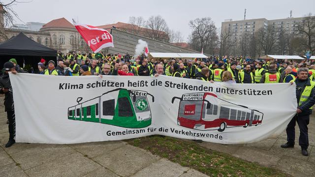 "Klima schützen heißt die Streikenden unterstützen - gemeinsam für die Verkehrswende" steht auf einem Transparent, das Verdi-Demonstranten in Berlin hochhalten.