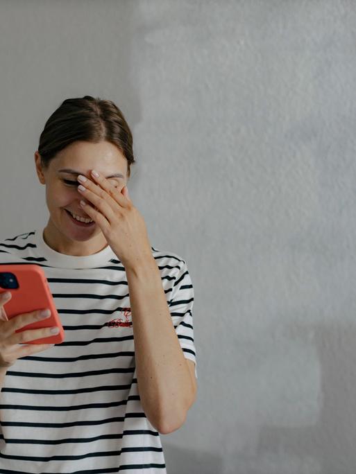 Eine Frau blickte vor ungefähr zehn Jahren offenbar peinlich berührt in ihr Handy.  Eine Frau blickte vor ungefähr zehn Jahren offenbar peinlich berührt in ihr Handy.