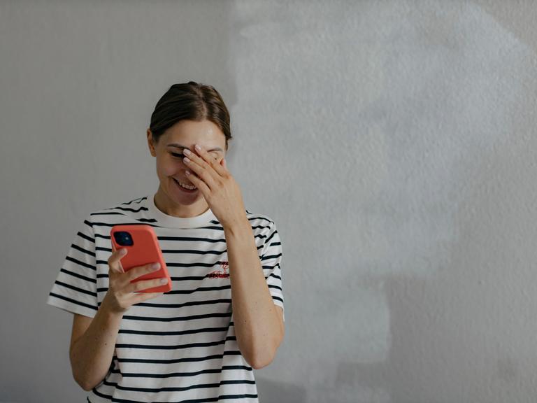 Eine Frau blickte vor ungefähr zehn Jahren offenbar peinlich berührt in ihr Handy.  Eine Frau blickte vor ungefähr zehn Jahren offenbar peinlich berührt in ihr Handy.