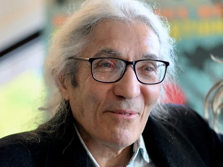 Das Bild zeigt den algerischen Schriftsteller Boualem Sansal. Er hat längere weiße Haare und trägt eine schwarze Brille.