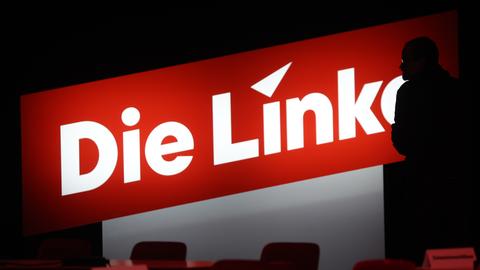 Ein Journalist steht vor dem neuen Logo der Partei Die Linke. 