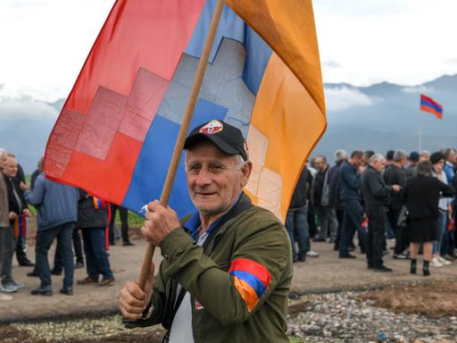 Ein Demonstrant mit einer Bergkarabach-Flagge ist während einer Kundgebung an der armenisch-aserbaidschanischen Grenze zu sehen. 