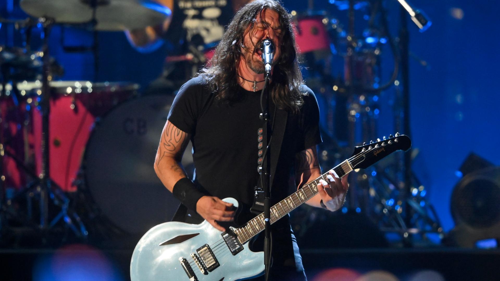 Dave Grohl spielt bei einem Konzert der Foo Fighters verschwitzt und mit wilden langen Haaren Gitarre. Foto: picture alliance