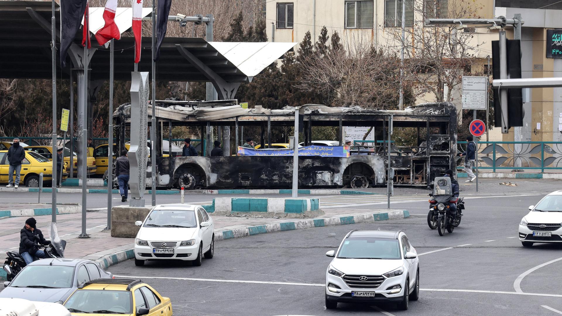 Eine Straßenkreuzung mit wenigen Autos und Menschen in Teheran.