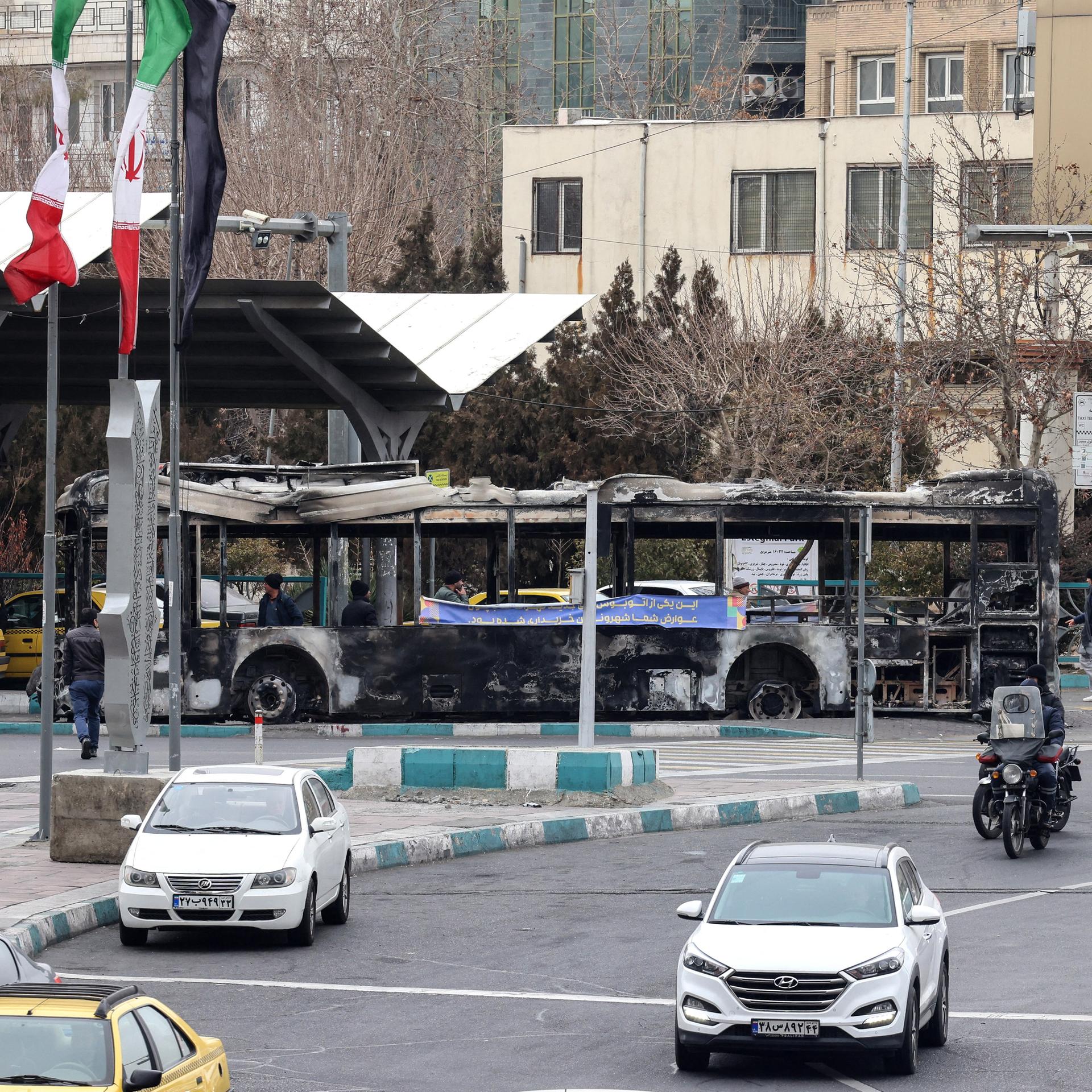 Eine Straßenkreuzung mit wenigen Autos und Menschen in Teheran.