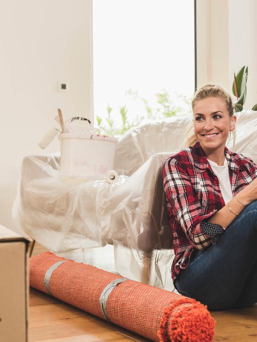 Eine Frau sitzt neben Umzugskartons.