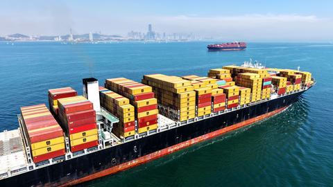 Ein Containerschiff vorm Hafen von Qingdao in China