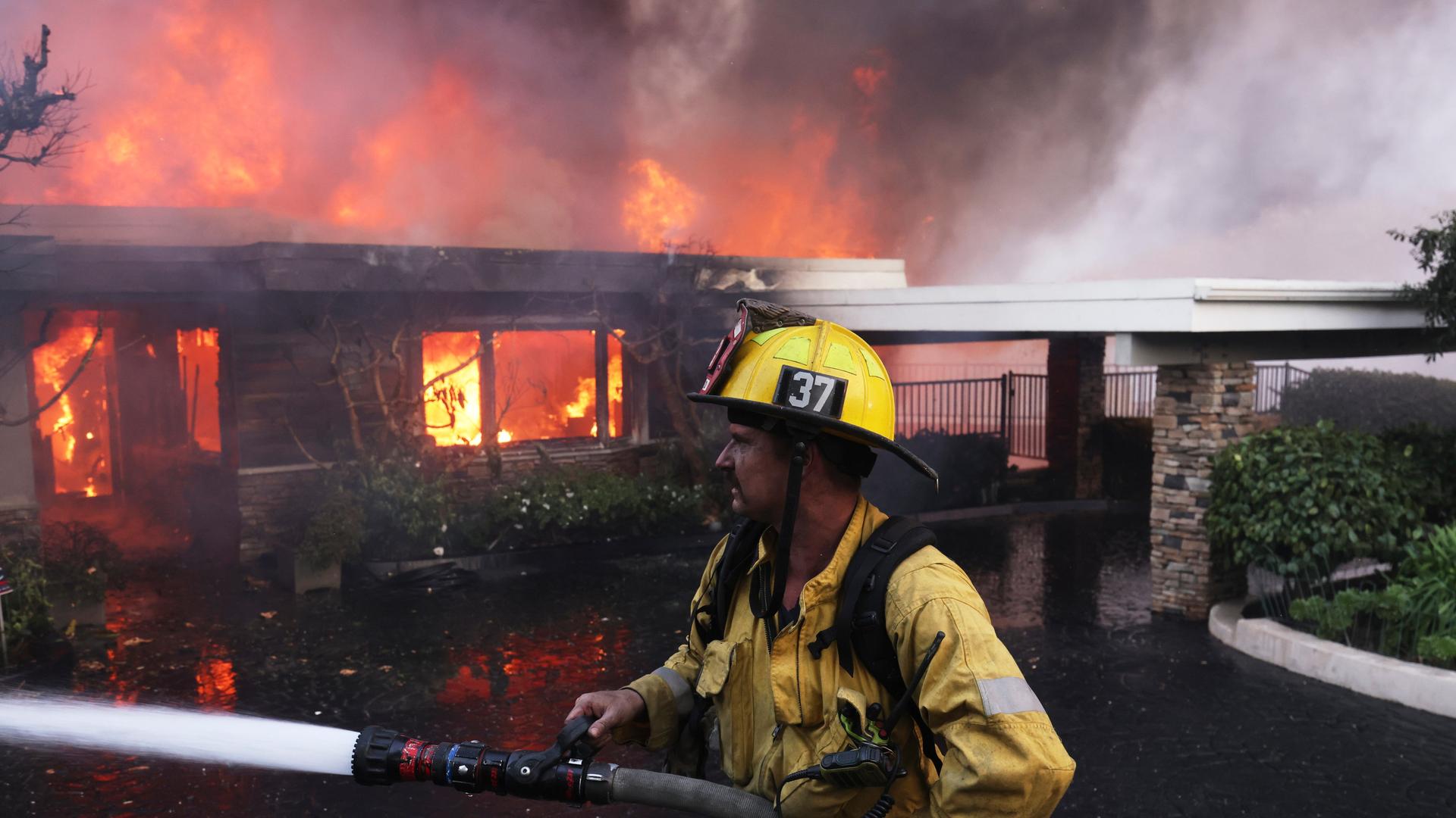 Ein Feuerwehr-Mann löscht einen Brand in einem Haus in Los Angeles.