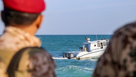 Uniformierte jemenitische Mitglieder der Küstenwachen schauen von einem Boot aus aufs Meer hinaus.